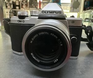 Olympus OM-D E-M10 II + M.Zuiko 45mm F1.8, Portrait-Festbrennweite, 2 Akkus + Ladegerät. Akkuverschluss-Feder fehlt (nutzbar). | Zustand: Gut