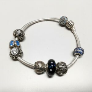 Pandora Moments Armband mit Charms, Silbernes Schlangenarmband mit verschiedenen Charms, darunter blaue und verzierte Elemente. | Zustand: Gebraucht | Farbe: silber
