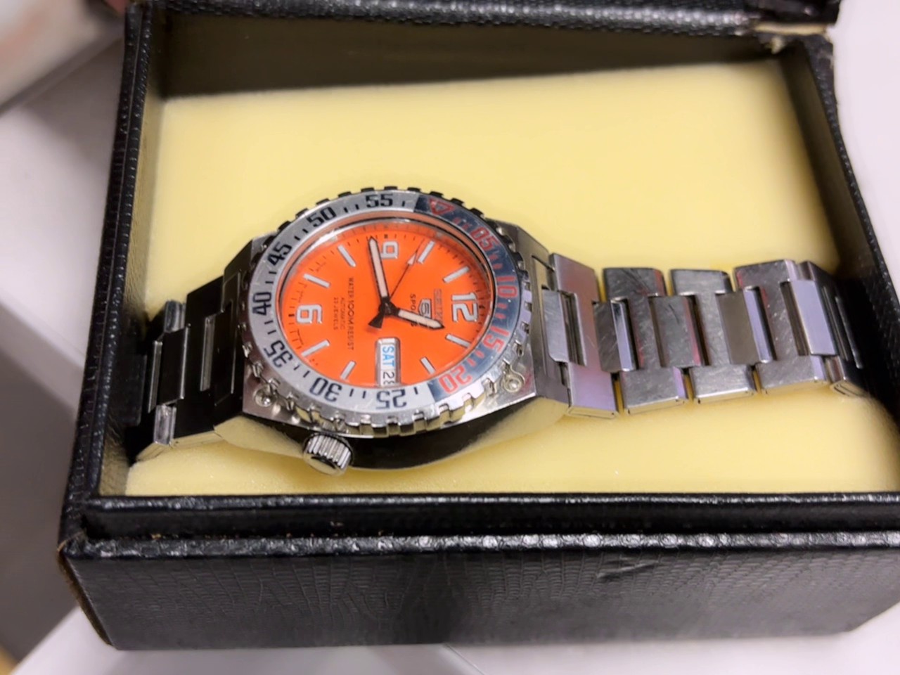 Seiko 5 Sports Orange Automatik, Orangefarbenes Zifferblatt, 100m WR, Automatikwerk mit 23 Steinen, Gebrauchsspuren am Armband, mit Box. | Zustand: Gebraucht | Farbe: gelb