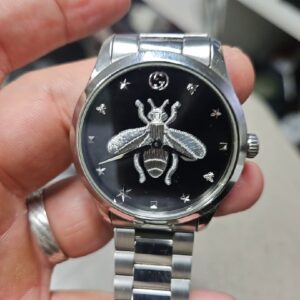 Gucci G-Timeless Bee Edelstahl Silber, Unisex-Armbanduhr, schwarzes Zifferblatt mit Bienen-Motiv, Quarzwerk, 5 ATM wasserdicht. | Zustand: Sehr Gut | Farbe: schwarz | Silber