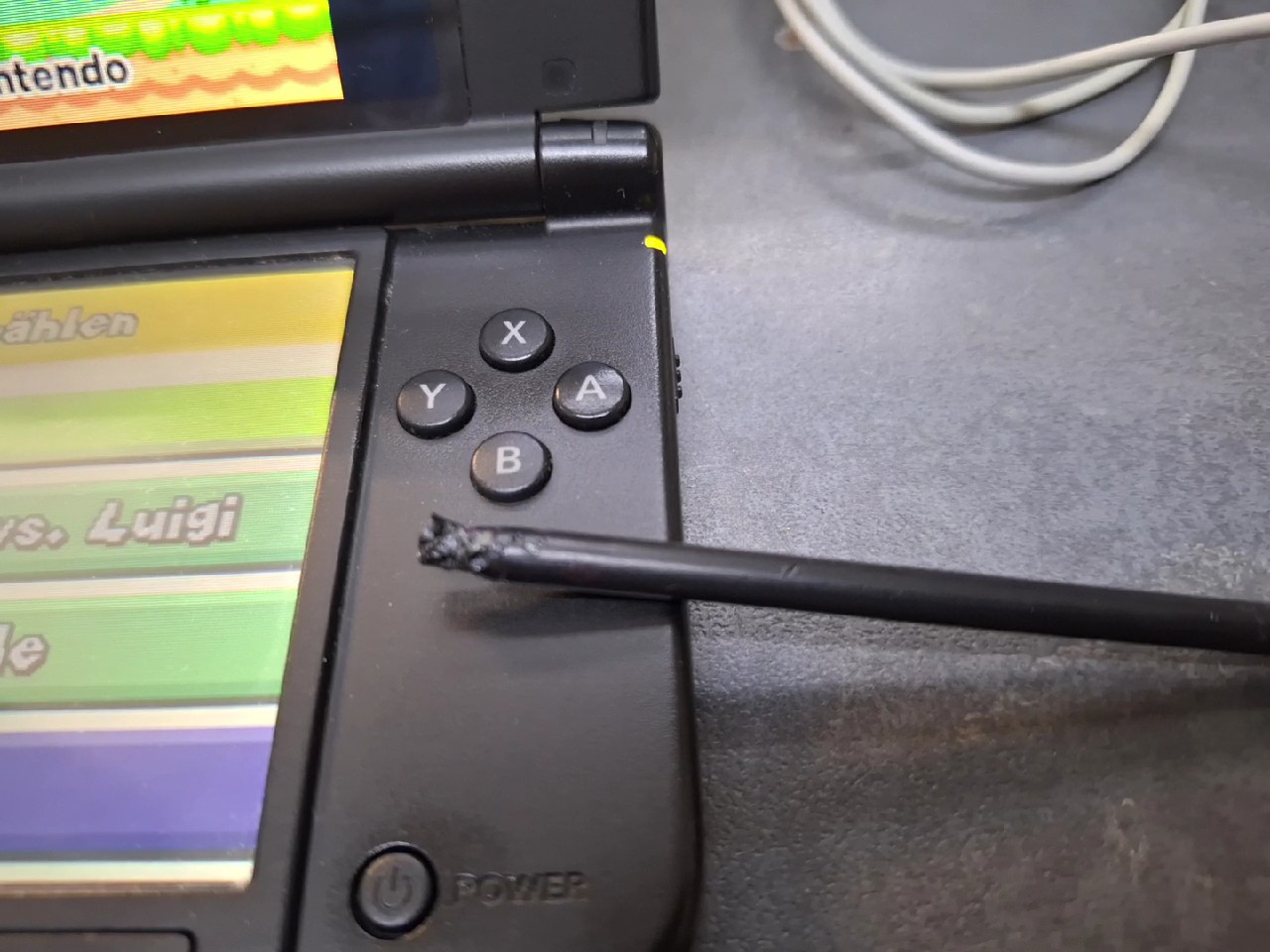 Nintendo 3DS XL Schwarz Silber, Handheld-Konsole inkl. Ladekabel und dem Spiel New Super Mario Bros., Gehäuse an der rechten Ecke gebrochen. | Zustand: In Ordnung | Farbe: schwarz – Bild 3