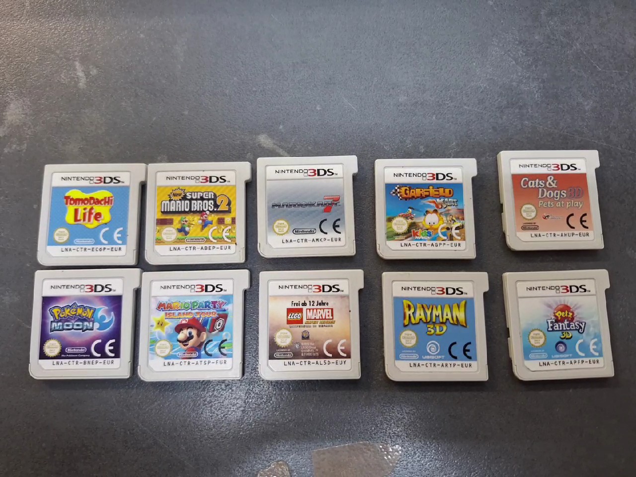 Nintendo 3DS Spiele-Set 10 Stk., 10 originale Nintendo 3DS Spielmodule inklusive Tomodachi Life, Pokémon Moon und Mario Kart 7. | Zustand: Sehr Gut | Farbe: grau